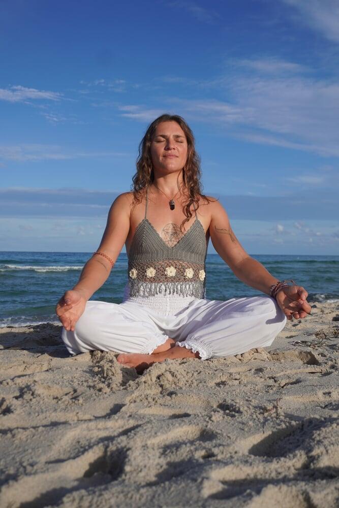 Atalia sitting on the beach in meditation